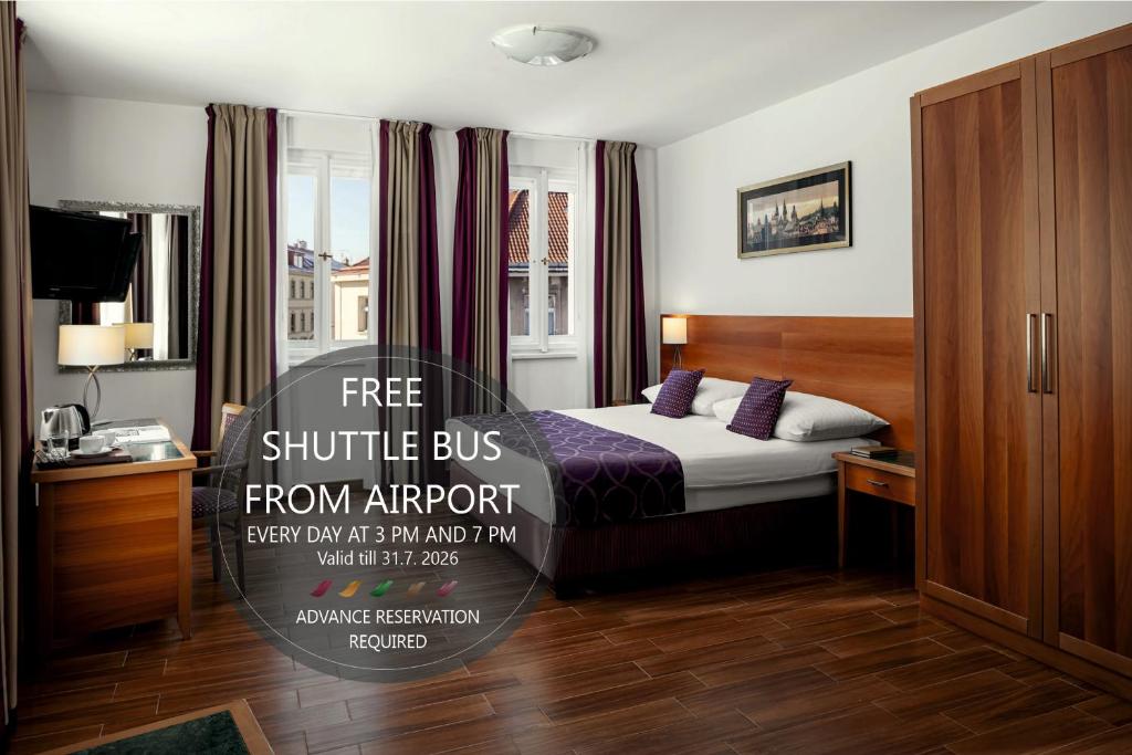 a hotel room with a bed and a sign that says free shuttle bus from airport at Hotel Galileo in Prague