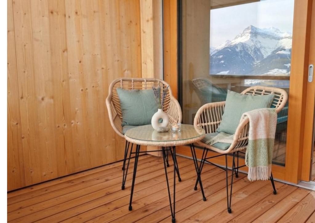 two chairs and a table on a porch at Moderne Ferienwohnung im Bregenzerwald in Au im Bregenzerwald