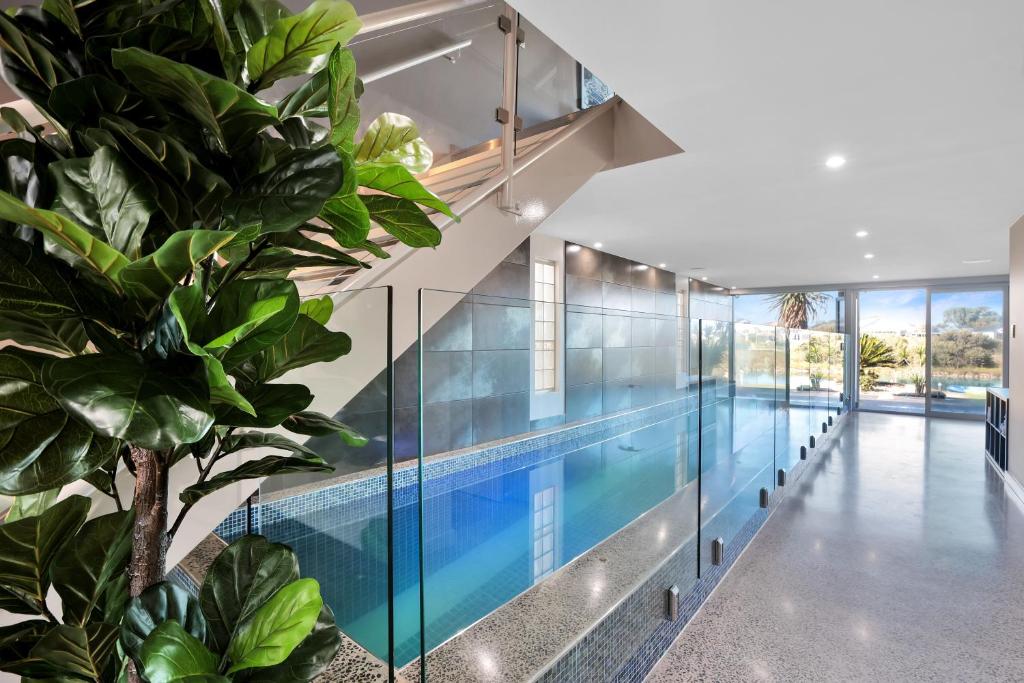 a swimming pool in a house with glass walls at Lakeside Serenity in Hindmarsh Island