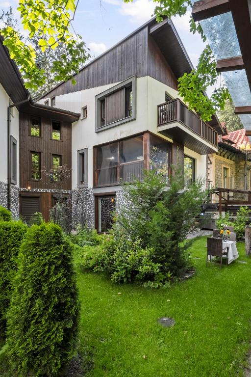 a house with a green yard in front of it at Drago Chalet Sinaia, hot tub and sauna in Sinaia