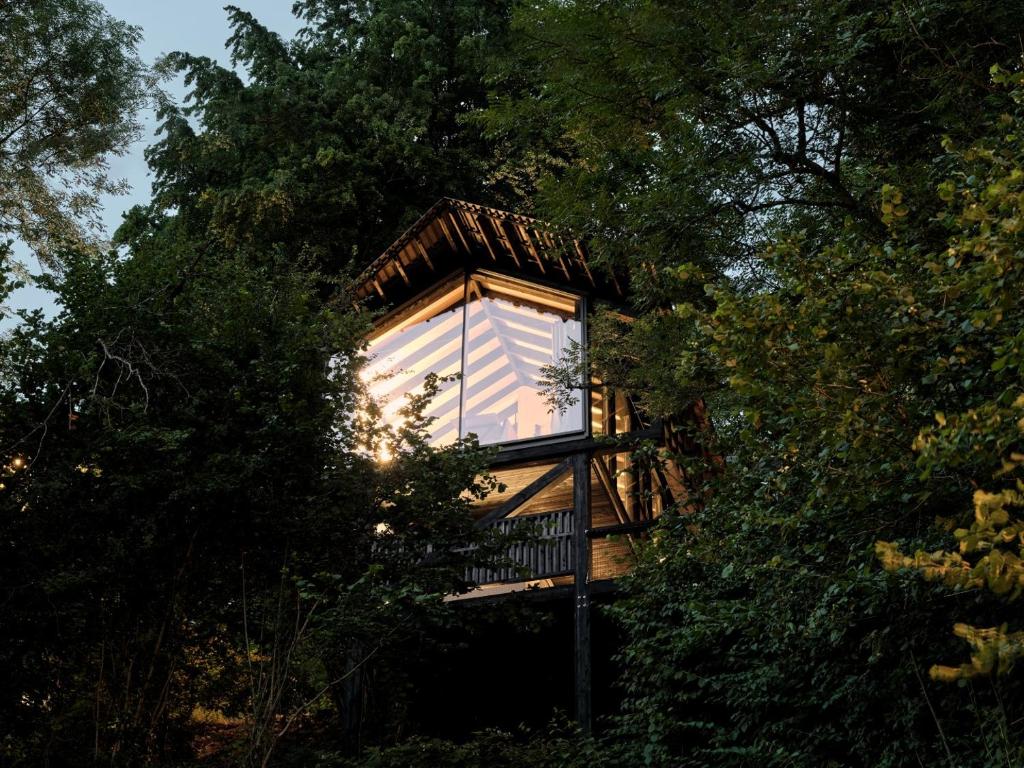 a tree house with a window in the middle of trees at Hutstuf La Roche-en-Ardenne in La-Roche-en-Ardenne