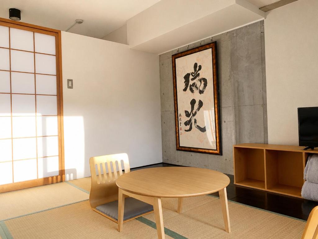 a living room with a table and a chair at Eight One in Osaka