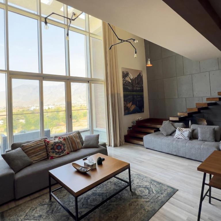 a living room with a couch and a table at Sifa Golf Lake in Muscat