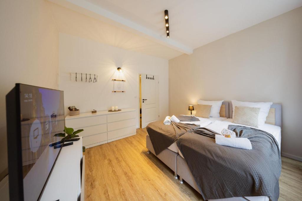 a bedroom with a bed and a flat screen tv at HYGGE HOMES - Apartment 'gamleby' in Lüneburg