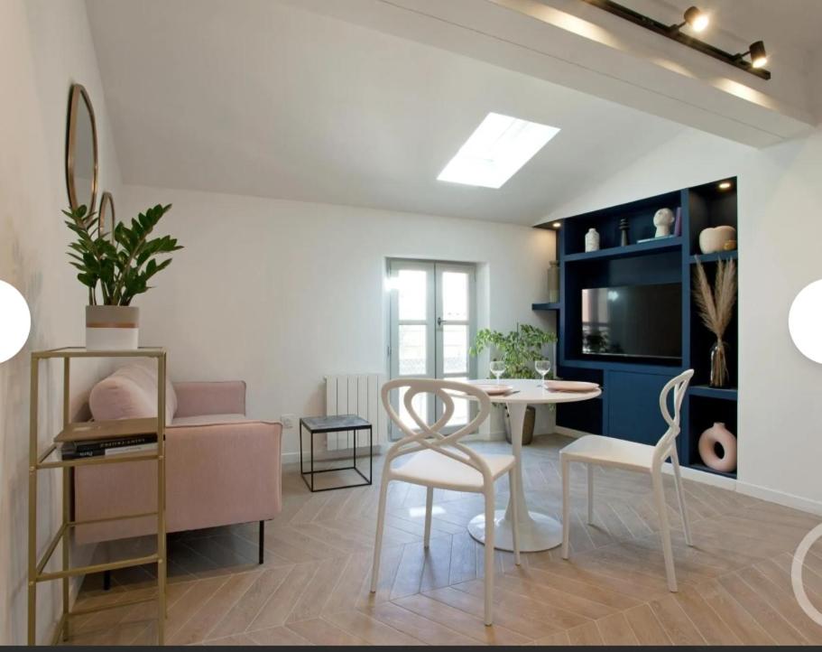 a living room with a table and chairs in a room at Cocon Voltaire - Arles centre historique in Arles