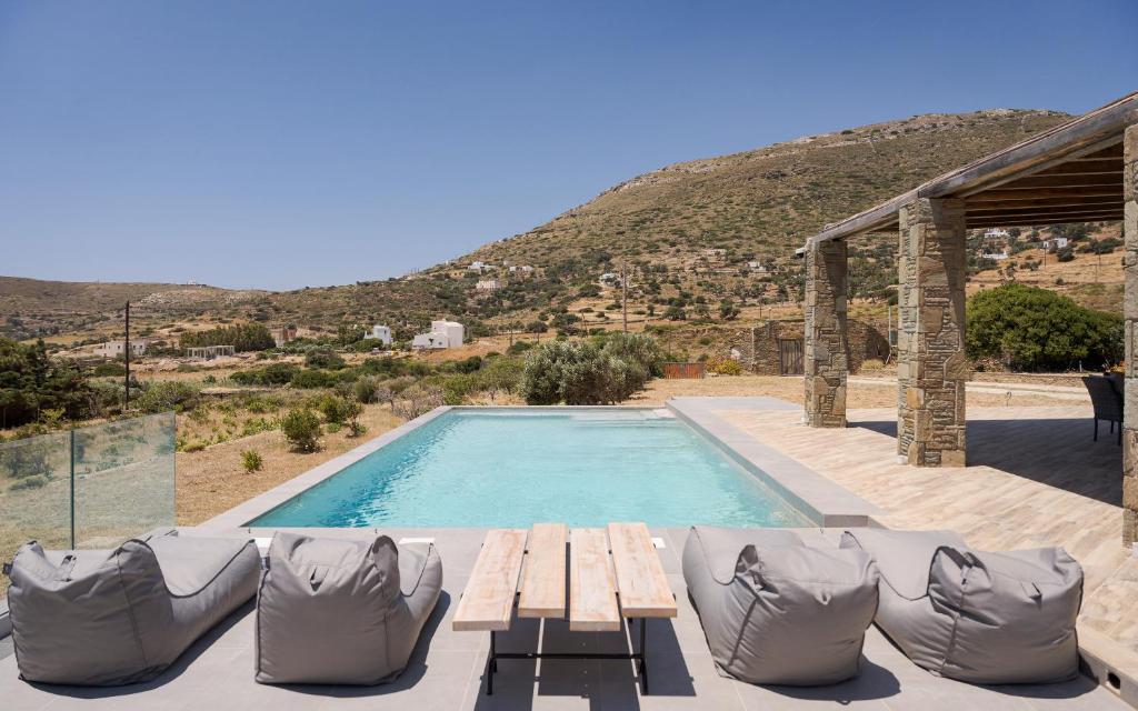 a swimming pool with a picnic table and chairs next to at Andros Royal Villa in Koumárion
