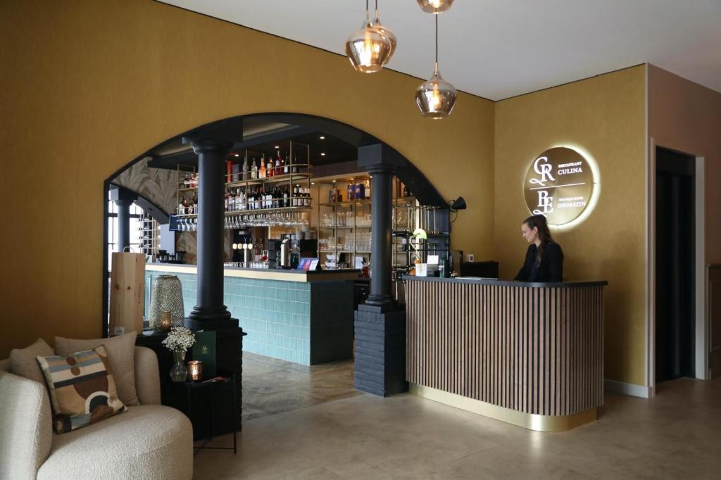 a woman standing at a bar in a restaurant at Boutique Hotel Enkhuizen in Enkhuizen