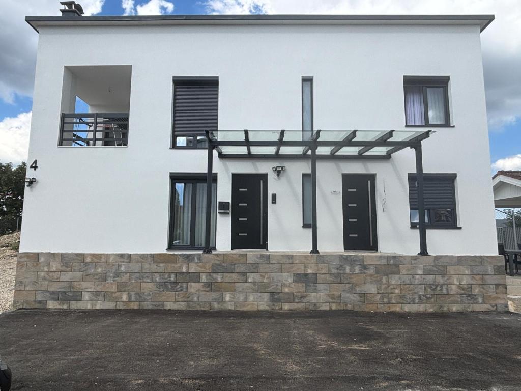 a white house with black doors and windows at Ferienwohnung Mina in Münsingen