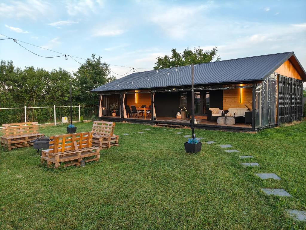 a house with a black roof and chairs in the grass at Cozy Box in Agapia