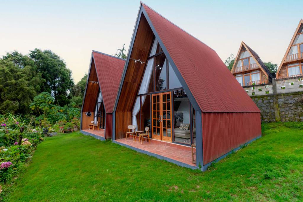 a barn with a red roof on a yard at Villa Platinum 2 in Banjarnegara