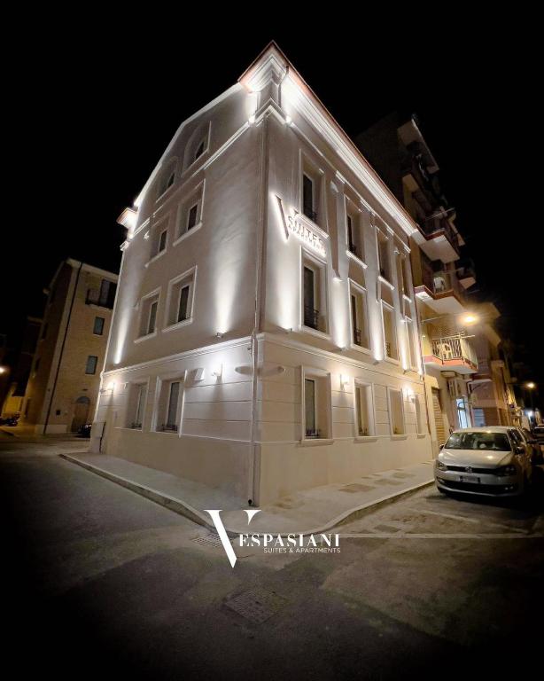 a white building with lights on it at night at Vespasiani Suites in San Benedetto del Tronto