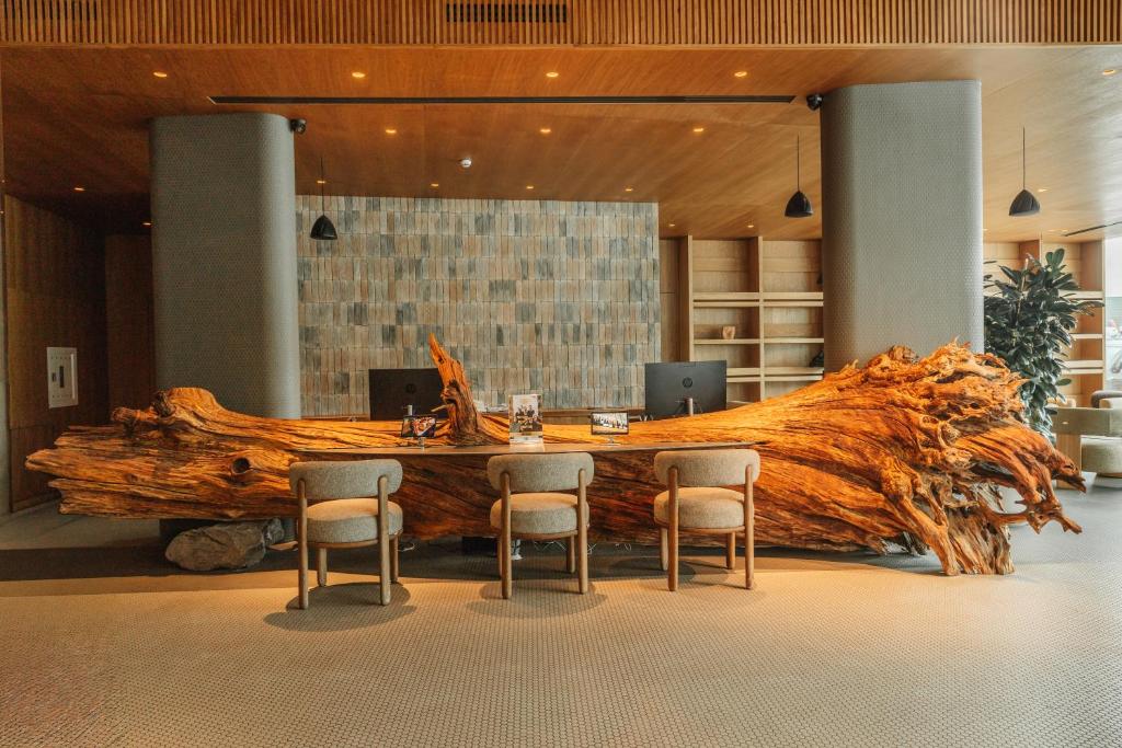 a large tree trunk in a room with a table and chairs at Fomich Estates in Bukovel