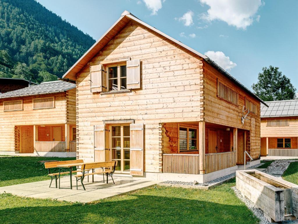 a wooden house with a picnic table in front of it at CASALPIN Chalets in Brand