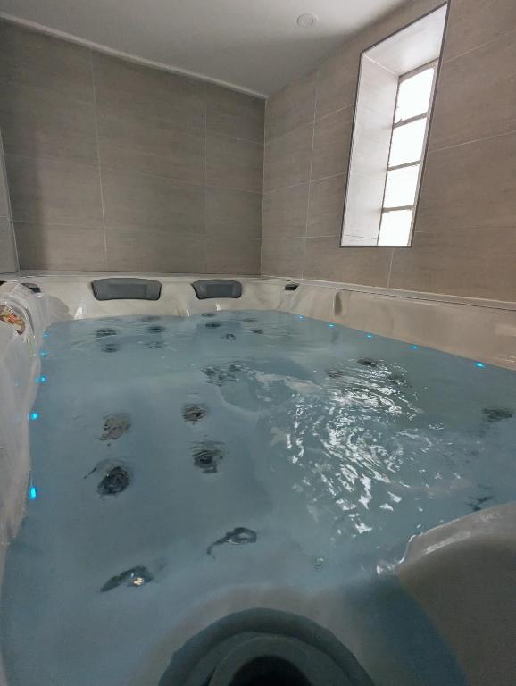 a large bath tub in a bathroom with a window at Maison hyper centre Jacuzzi in Amboise