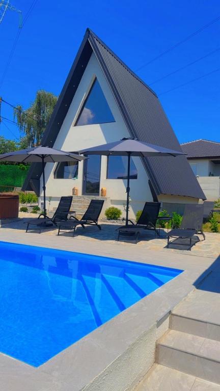 a house with a swimming pool and two umbrellas at Laganini house Vinča in Belgrade