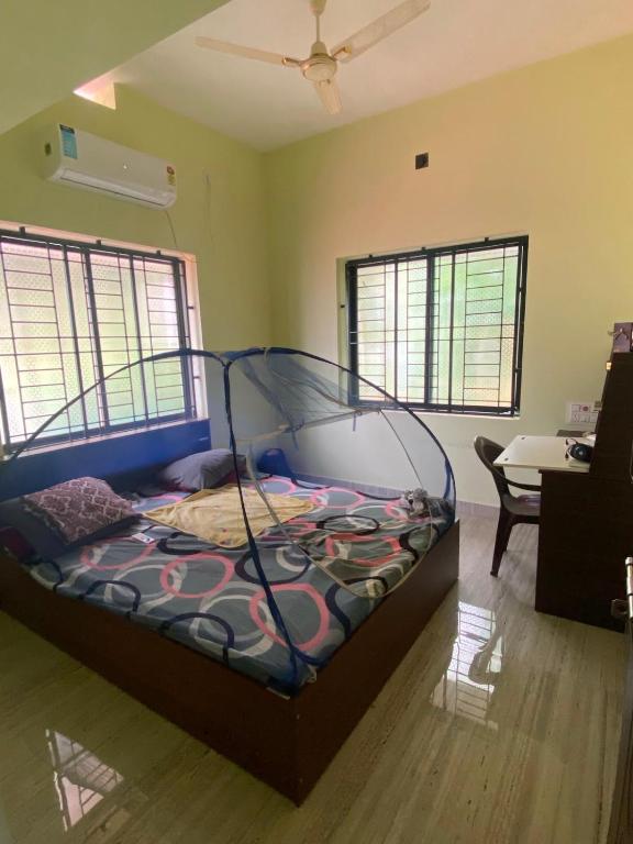 a bedroom with a bed in a room with windows at Siya's home in Udupi