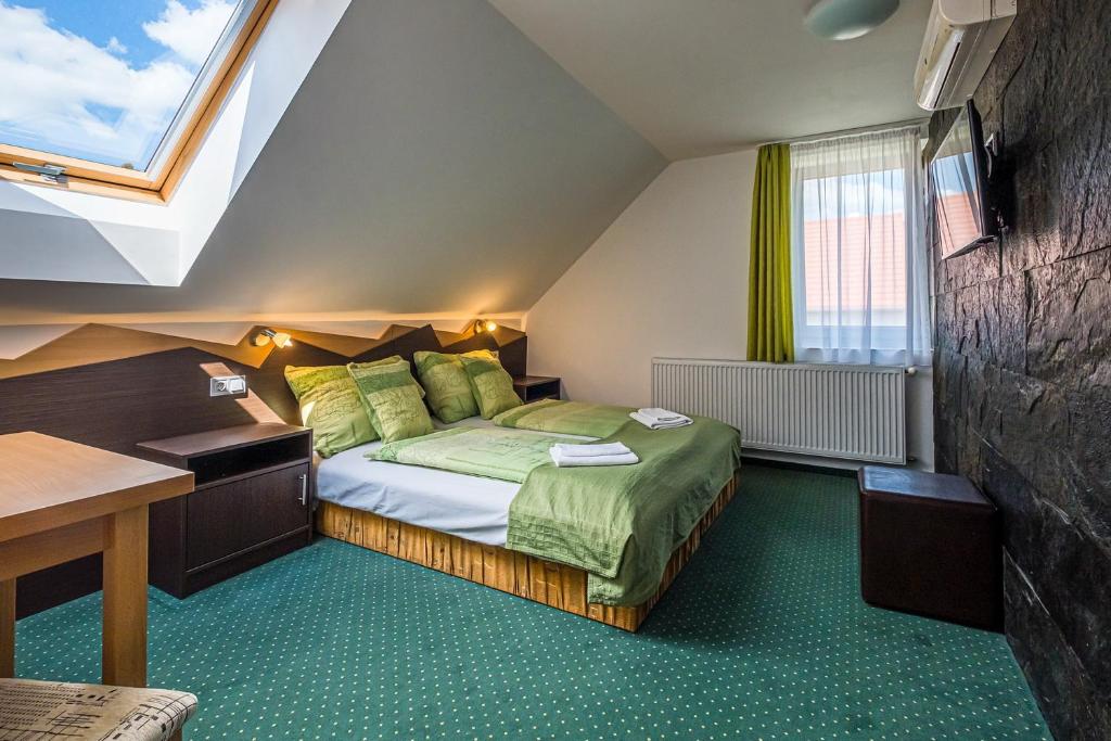 a bedroom with a bed and a desk and a window at Babi Guesthouse - Babi Vendégház in Balatonfüred