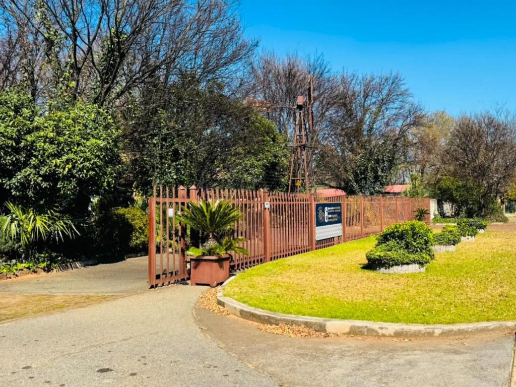 a wooden fence with plants in a yard at Kriel Windpomp Guesthouse in Aangewysd