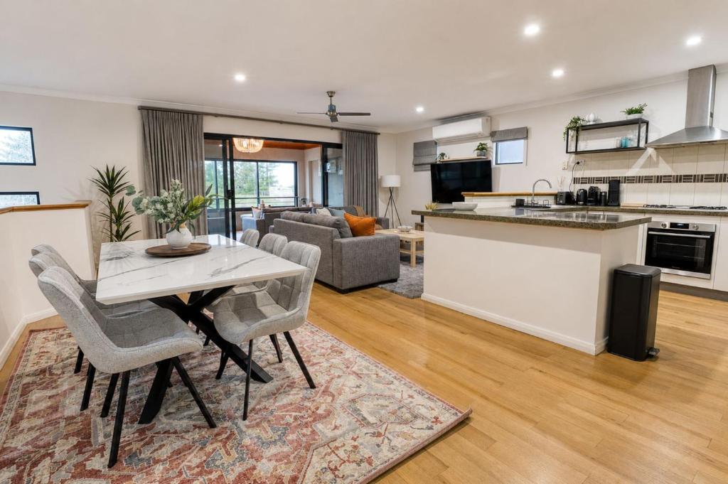 a kitchen and living room with a table and chairs at Saltwater Stay in Bunbury