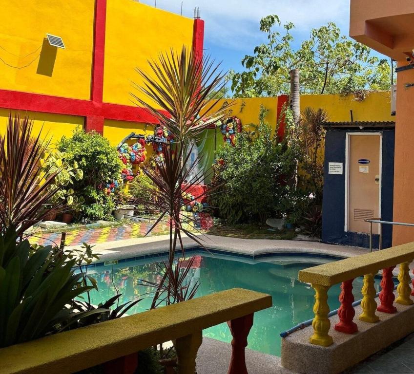 a swimming pool with a bench in front of a building at Buku Island House in san juan la union