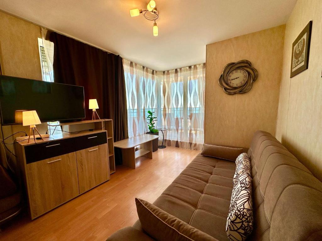 a living room with a couch and a flat screen tv at Cozy Corner Studio in Crown Fort in Sveti Vlas