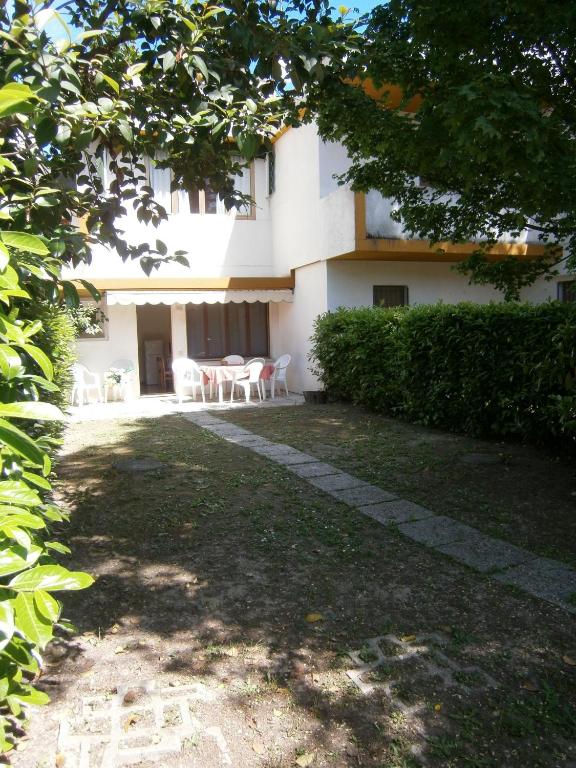 a building with tables and chairs in a yard at Capri in Bibione