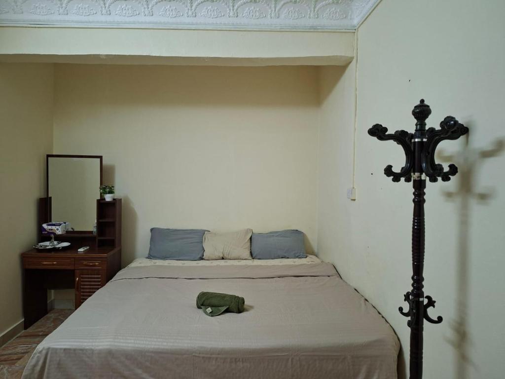 ein Schlafzimmer mit einem Bett mit einem grünen Hut darauf in der Unterkunft Ur place in al-Ain
