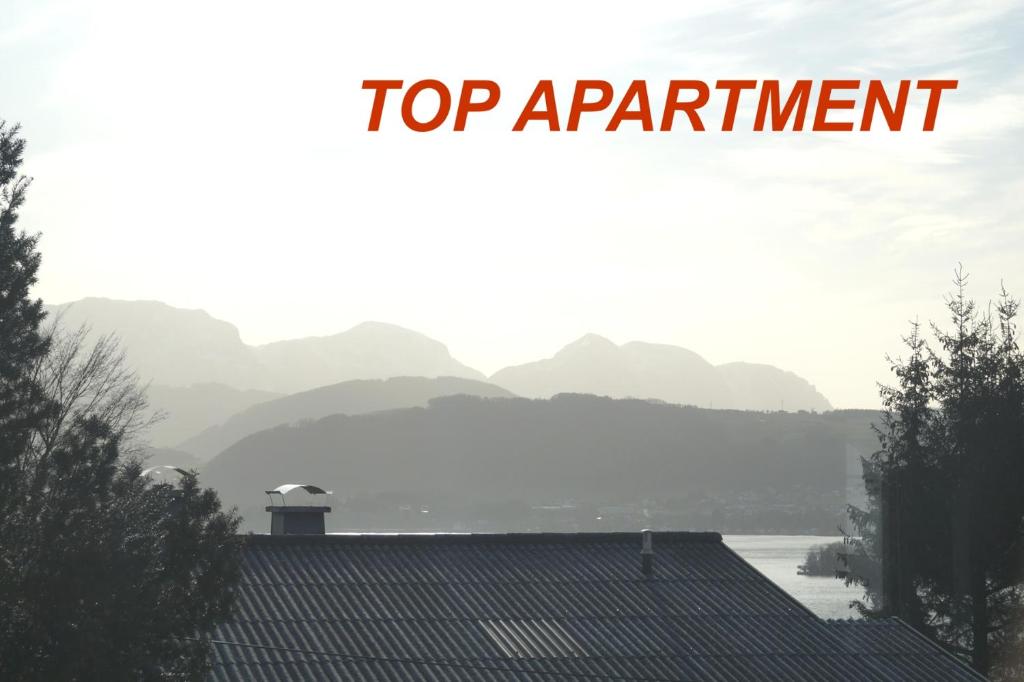 ein Schild, auf dem steht Top-Termin auf einem Dach mit Bergen im Hintergrund in der Unterkunft Grünbergnahe Wohnung 45m2 und weißes Zimmer 17 m2 in Gmunden