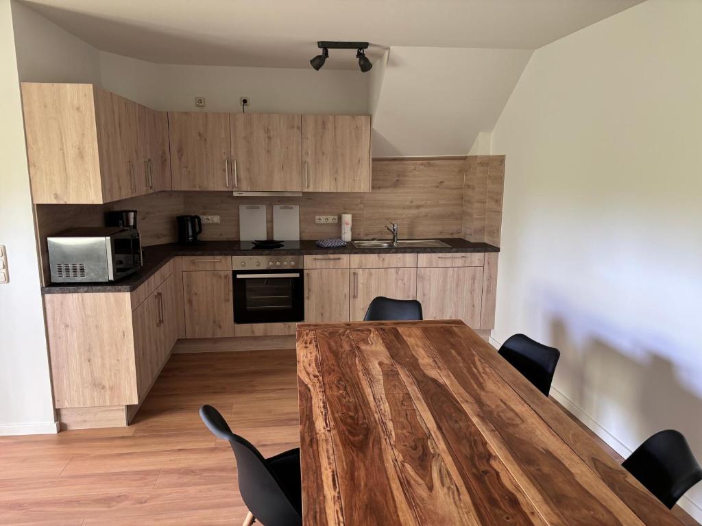 a kitchen with a wooden table and chairs at Hochwertige Monteurunterkunft in Zarrentin