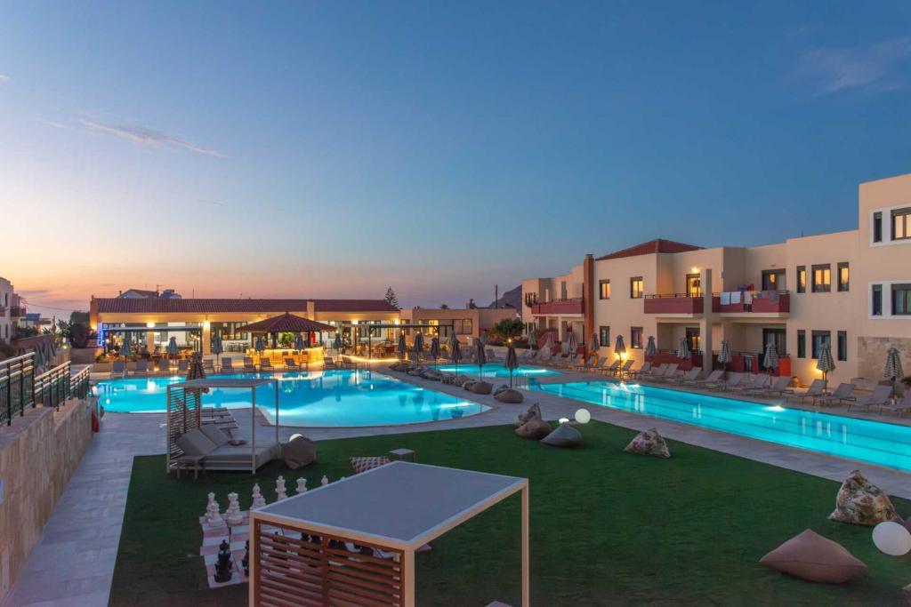 a large swimming pool in front of some buildings at Kambos Village in Agia Marina Nea Kydonias