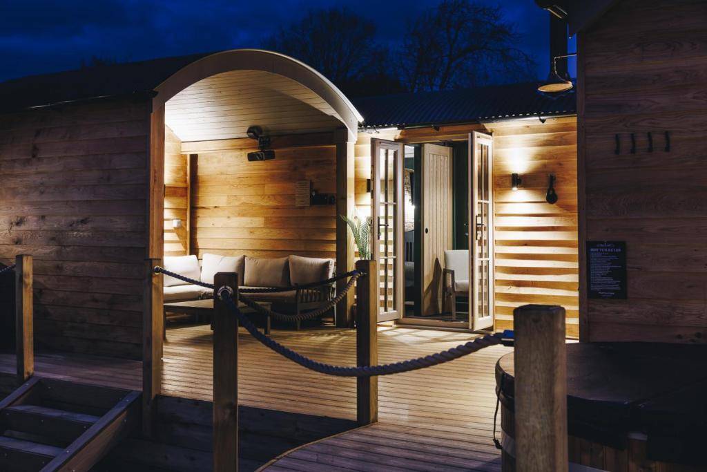a wooden deck with a swing and a chair at Nestledstays - The Hide in Walberton