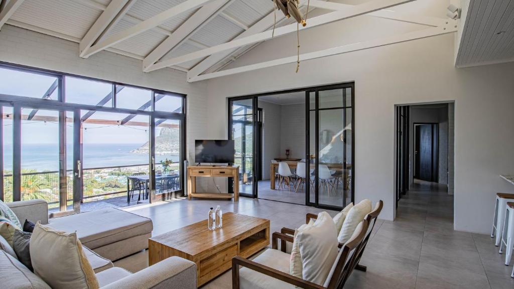 a living room with a couch and a table at Sunset Bay Stay in Hout Bay