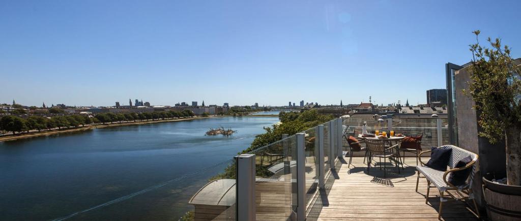a balcony with a table and chairs and a view of a river at Central Penthouse with Private Rooftop Terrace in Copenhagen