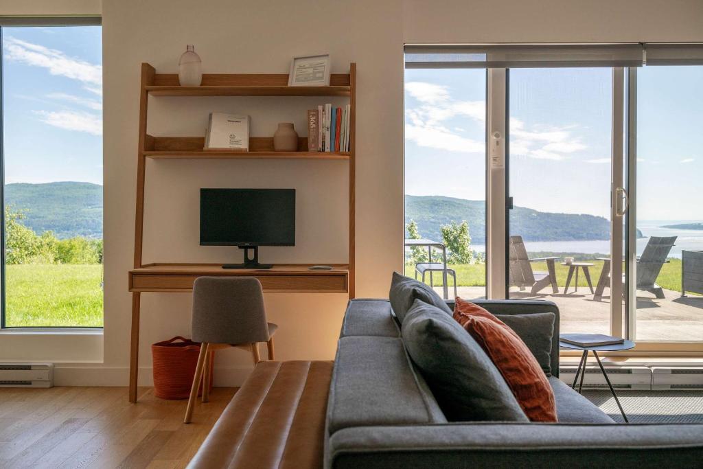 a living room with a couch and a television at 102 - Upscale Condo - River View Terrace in Baie-Saint-Paul