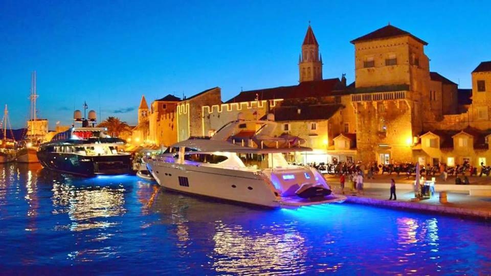 dois barcos ancorados num porto em frente a uma cidade em Apartments Silvana em Trogir