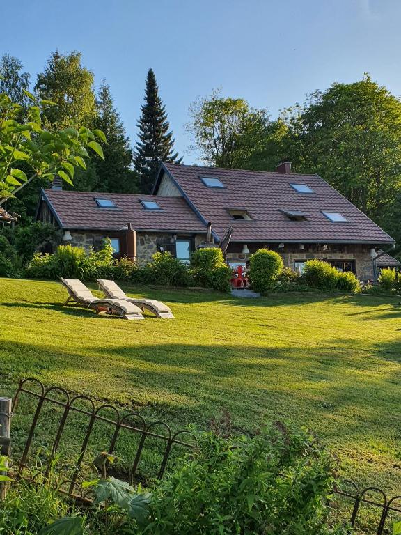 a house with a yard with two benches in the grass at Braeschenberg in Breitenbach-Haut-Rhin