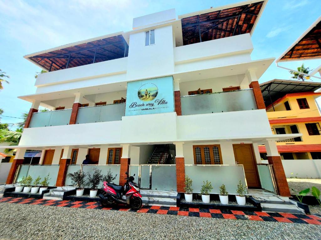 a building with a scooter parked in front of it at Beach Way Villa in Varkala