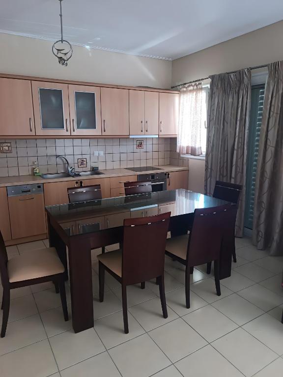 a kitchen with a large wooden table and chairs at Gialova Relax in Korifásion