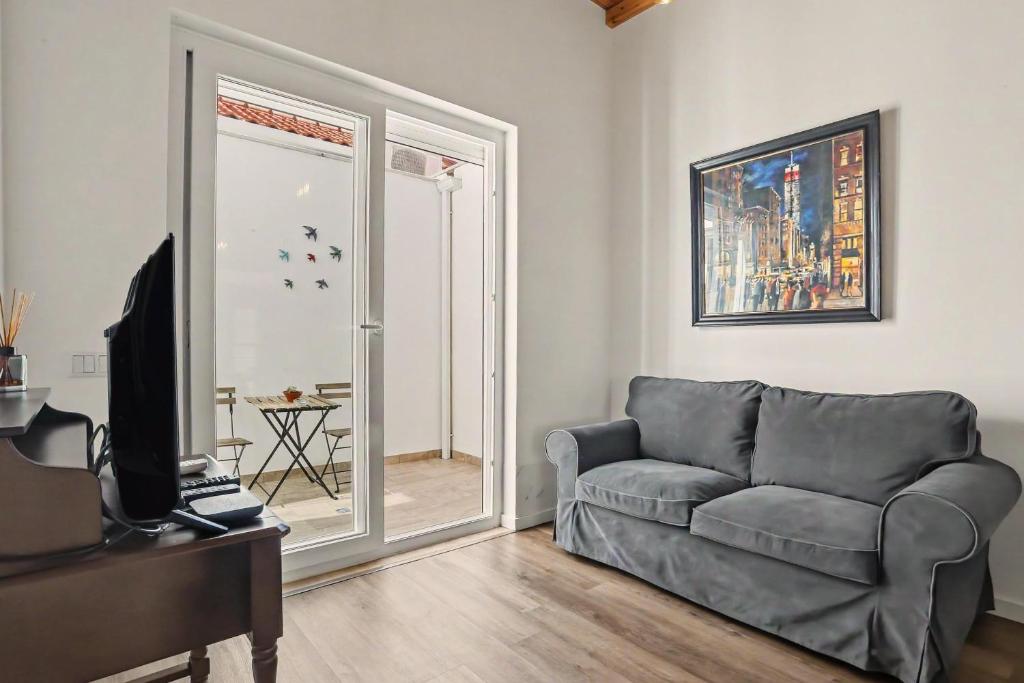 a living room with a couch and a window at Casa Albano 3 in Caldas da Rainha