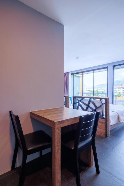A small dining table with two chairs sits beside the bedroom window.