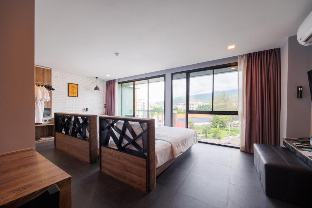 A modern bedroom faces broad windows with a city-and-mountain outlook.
