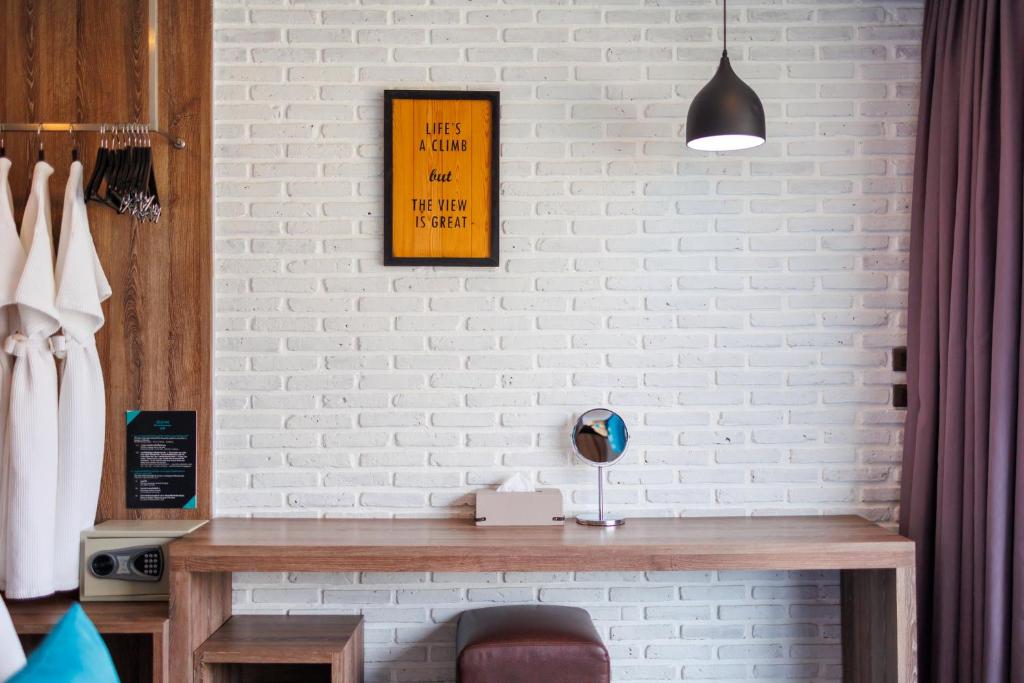 A built-in writing desk sits beneath a pendant light beside an open wardrobe.