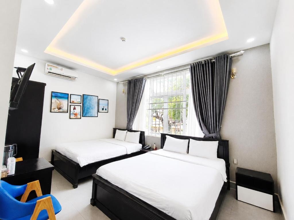 a hotel room with two beds and a window at THAO LIEN HOTEL in Con Dao