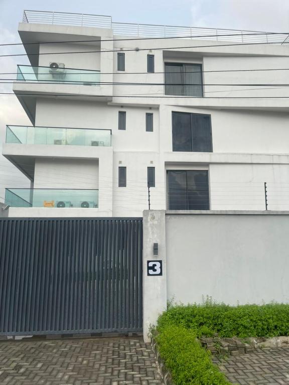 a white building with a fence in front of it at The Abode in Lekki Phase 1