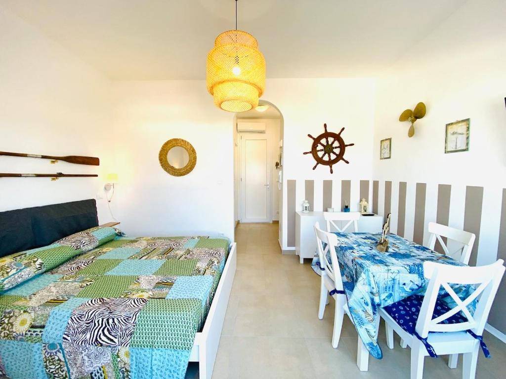 a bedroom with a bed and a table and chairs at Vear Hausing - Piramidi 17 in Lido delle Nazioni