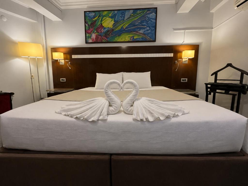 two white swans making a heart on a bed at Mola INN Uşak in Uşak