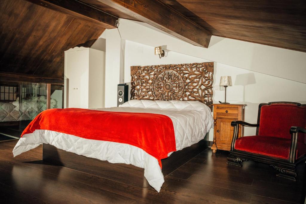 クエンカにあるApartamentos 1177のベッドルーム1室(ベッド1台、赤い椅子付)