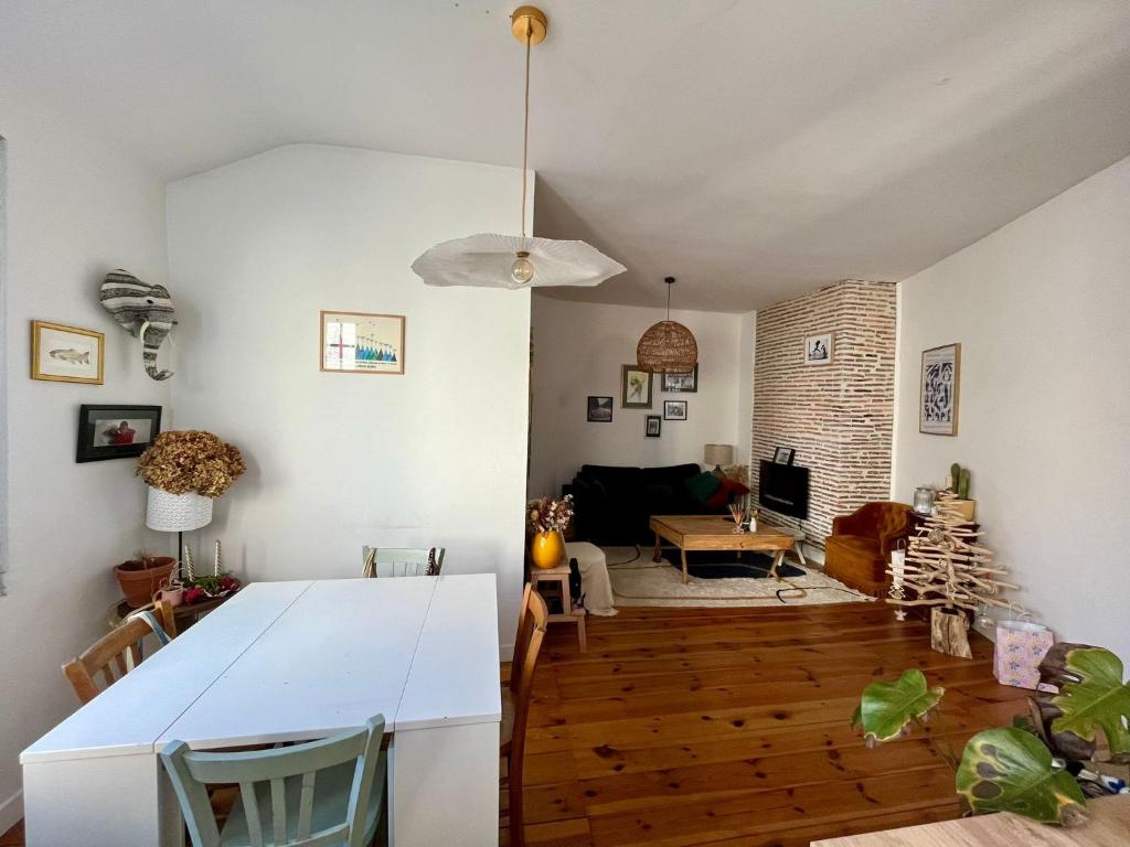 a kitchen and living room with a white table at Cosy Néroli - T3 - Parking privée plein centre ville in Pau