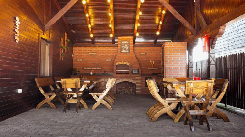 a patio with wooden tables and chairs and a fireplace at Casa Om Bun in Beclean