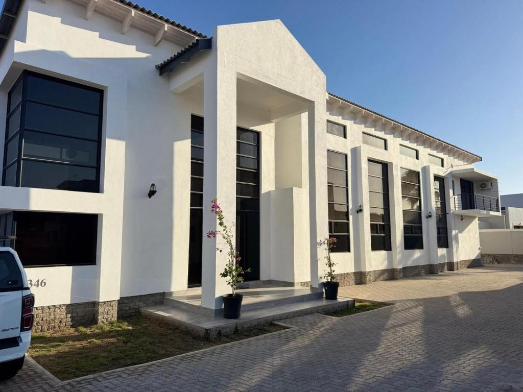 a white building with a car parked in front of it at Carlo's Fairview Boutique - Hotel in Walvis Bay